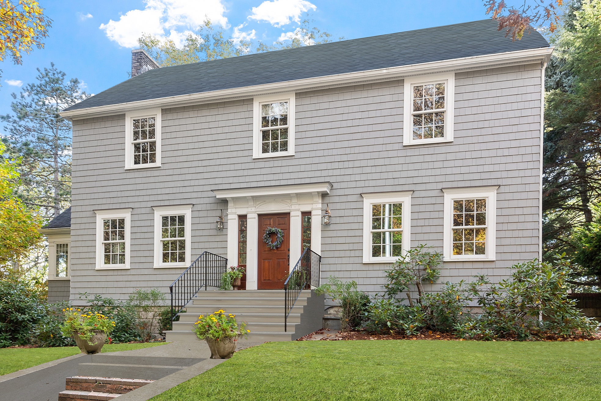 Renovated colonial home exterior with gray shingle siding in Medford, MA